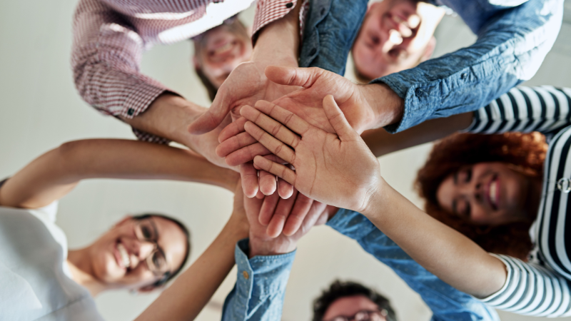 A diverse group of individuals united, holding hands together in a powerful display of unity and solidarity.