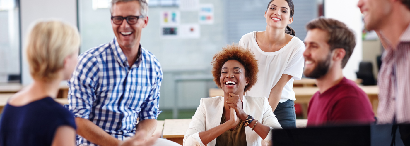 Company get together with people in business wear gathered in a group laughing and talking