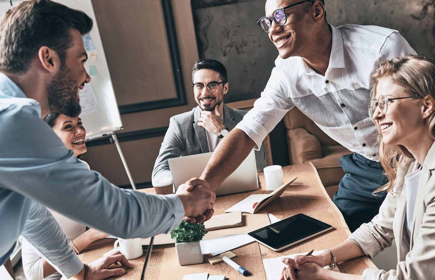 Happy group of IT business professionals at a meeting and shaking hands