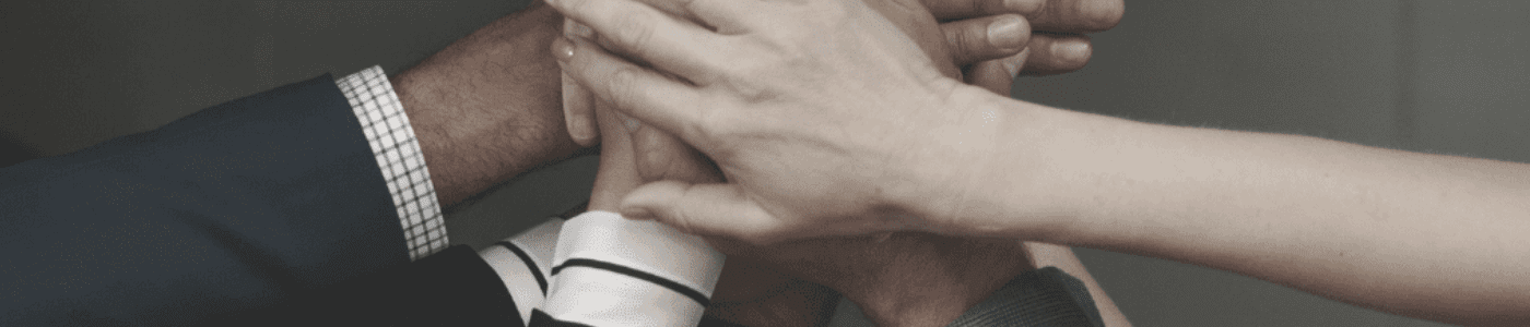 A diverse set of business professionals putting their hands in demonstrating teamwork