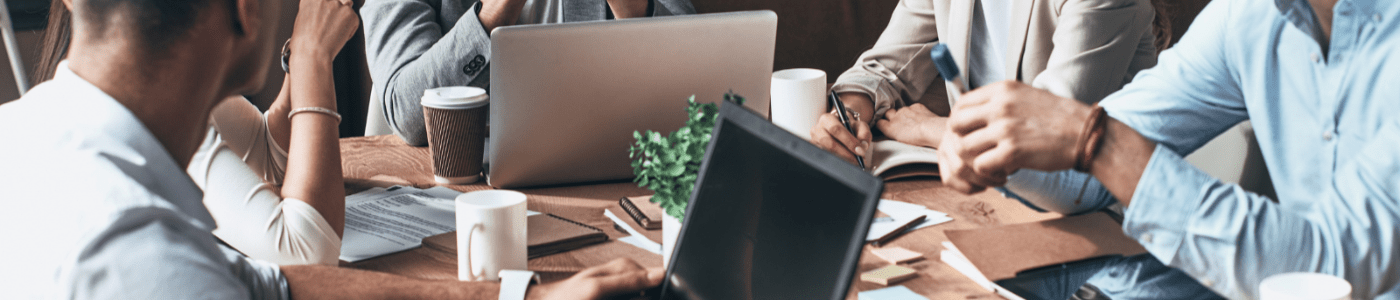 A group of business professionals sitting around a table working on computers