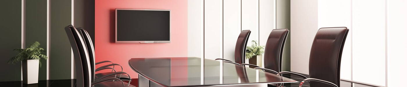 Business meeting room with a large table surrounded by office chairs