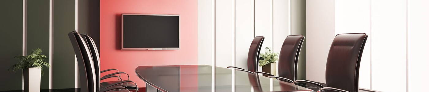 Business meeting room with a large table surrounded by office chairs