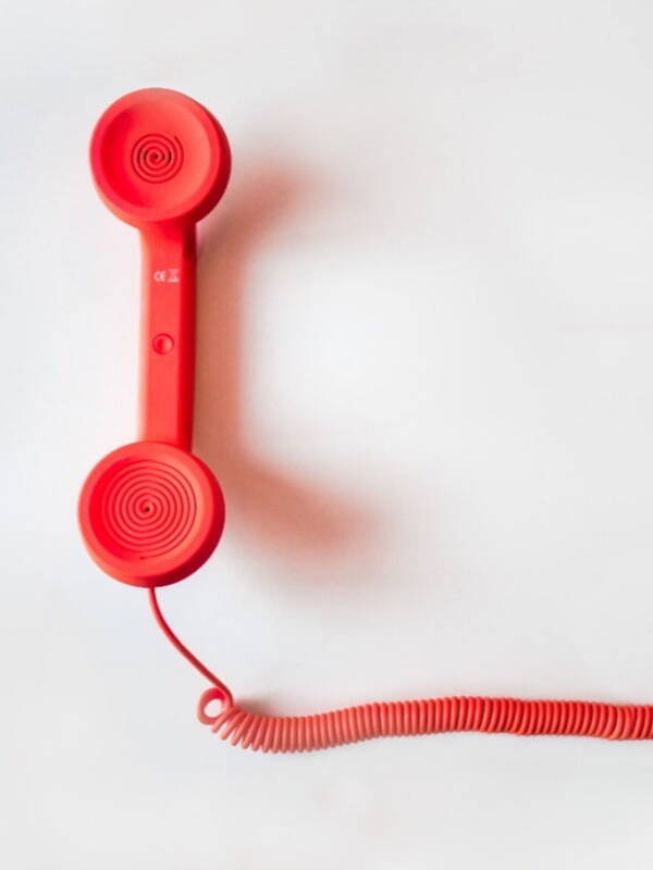 Red phone with cord on white background