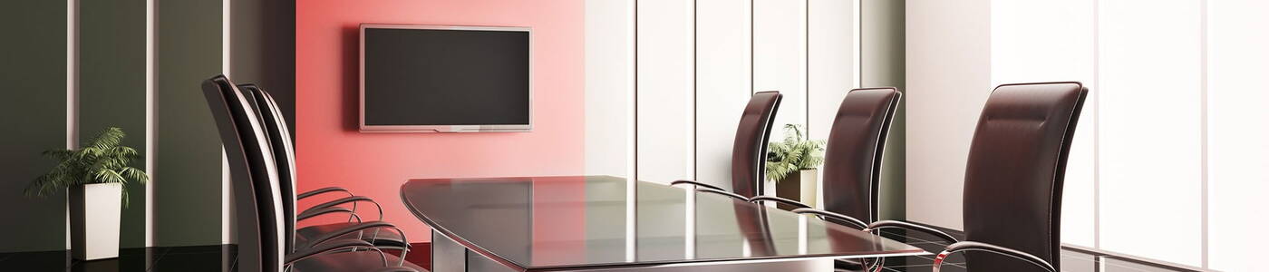 Business meeting room with a large table surrounded by office chairs