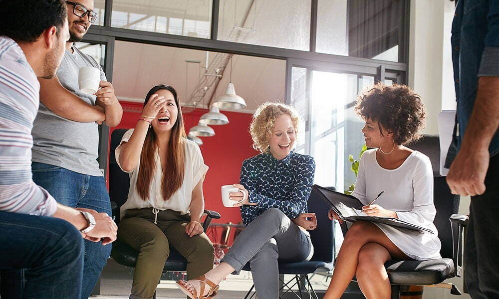 Happy group of diverse individuals sitting in a circle having a discussion